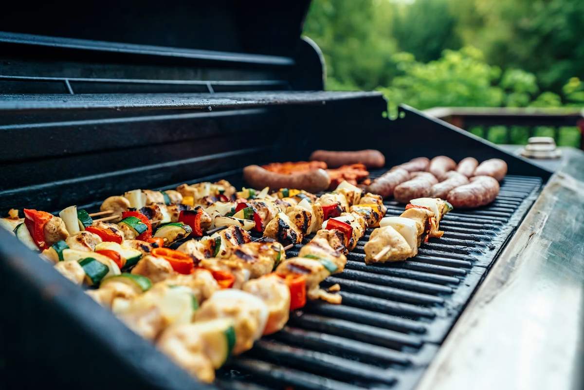 summer bbq recipes Colorful kebabs and sausages cooking on a barbecue grill