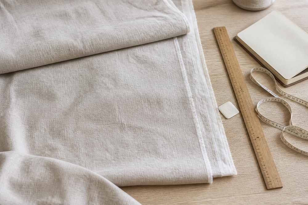 Linen curtain fabric measured on a worktable before cutting