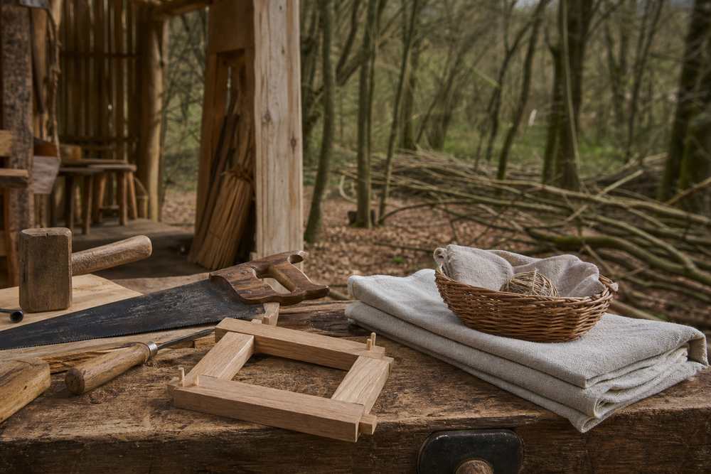 Traditional woodland tools and folded linen on a timber workbench