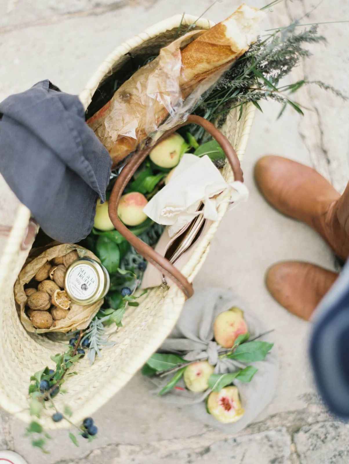 Simple picnic food arranged in reusable containers on a light cloth