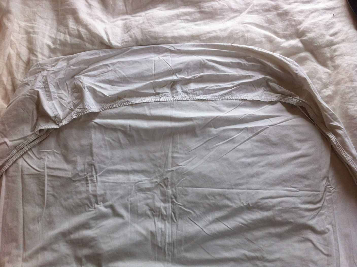 Step 2: nest the fitted-sheet corners One fitted-sheet corner tucked inside another