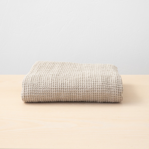 Folded natural linen waffle towel showing its textured weave