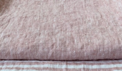 Linen fabric being gently stretched by hand