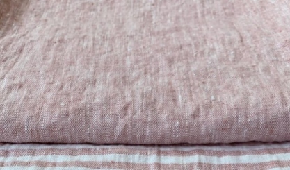 Linen fabric being gently stretched by hand