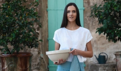 Natural linen cross-back apron hanging in a calm working kitchen