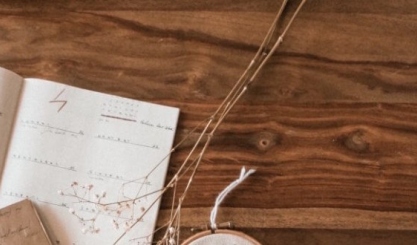Linen travel bag packed with neutral clothes, a book and paper map
