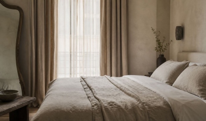 Boutique hotel bedroom styled with natural linen bedding and curtains