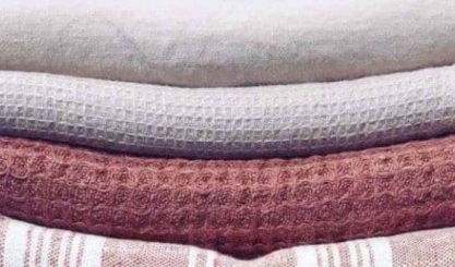 Neatly folded linen textiles stored in a breathable stack