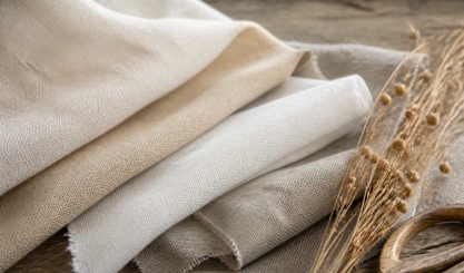 Neutral linen fabric swatches showing natural weave beside dried flax stems