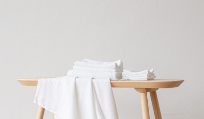 White linen cleaning cloths arranged on a wooden bench