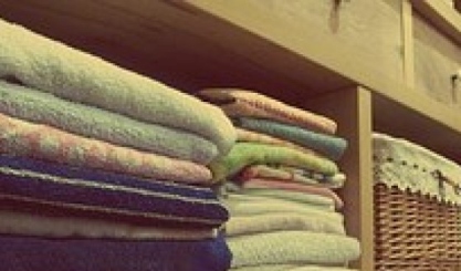Neatly folded fitted sheet prepared for organised linen storage