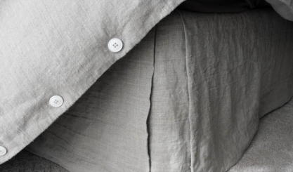 Linen flat sheet arranged on a bed