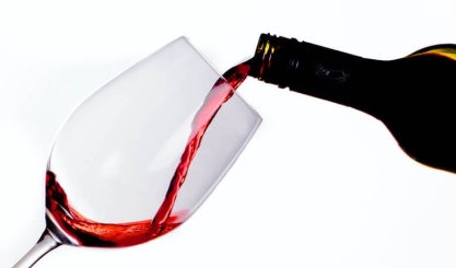 Red wine beside white linen fabric