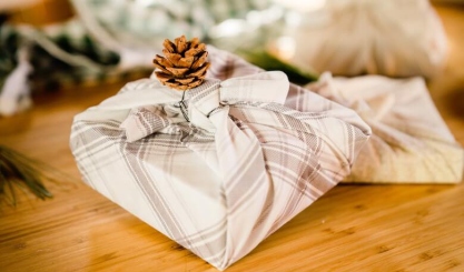 Reusable gifts wrapped in neutral linen fabric with simple natural ties