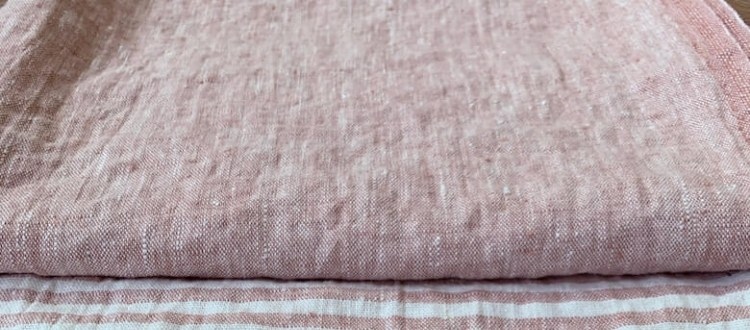 Linen fabric being gently stretched by hand