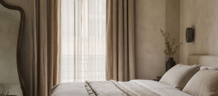 Boutique hotel bedroom styled with natural linen bedding and curtains