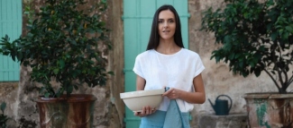 Natural linen cross-back apron hanging in a calm working kitchen