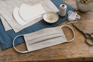 Linen face covering sewing project with fabric, pattern, elastic and thread