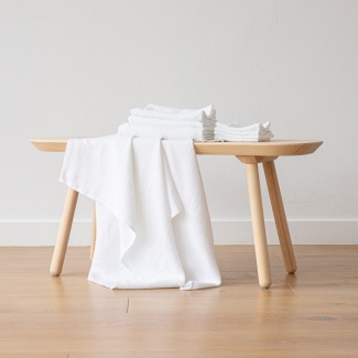 White linen cleaning cloths arranged on a wooden bench