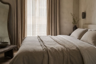 Calm hotel bedroom styled with neutral linen bedding and curtains