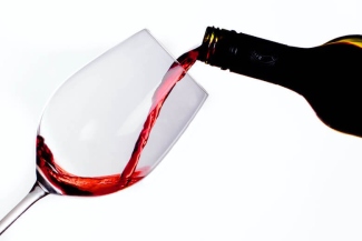 Red wine beside white linen fabric