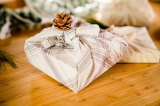 Reusable gifts wrapped in neutral linen fabric with simple natural ties