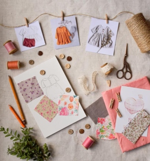 Linen craft workspace with offcuts, thread, scissors and a stitched sachet